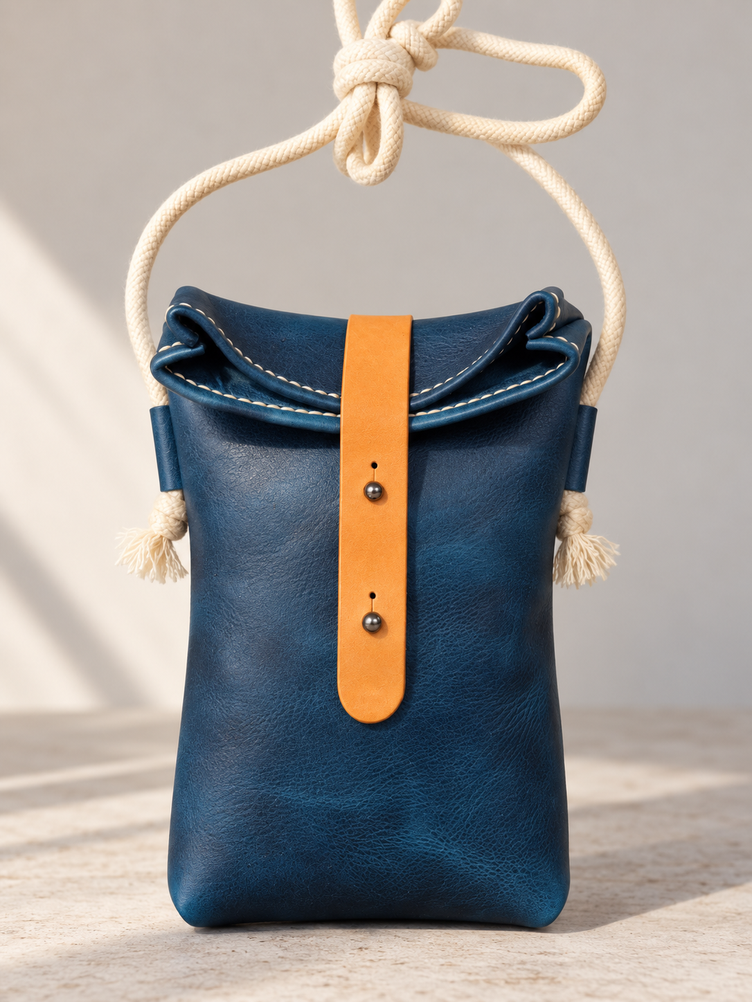 Handgefertigte Leder-Rolltop-Tasche „Mara“ mit Kordelriemen. Detail Blau Verschluss