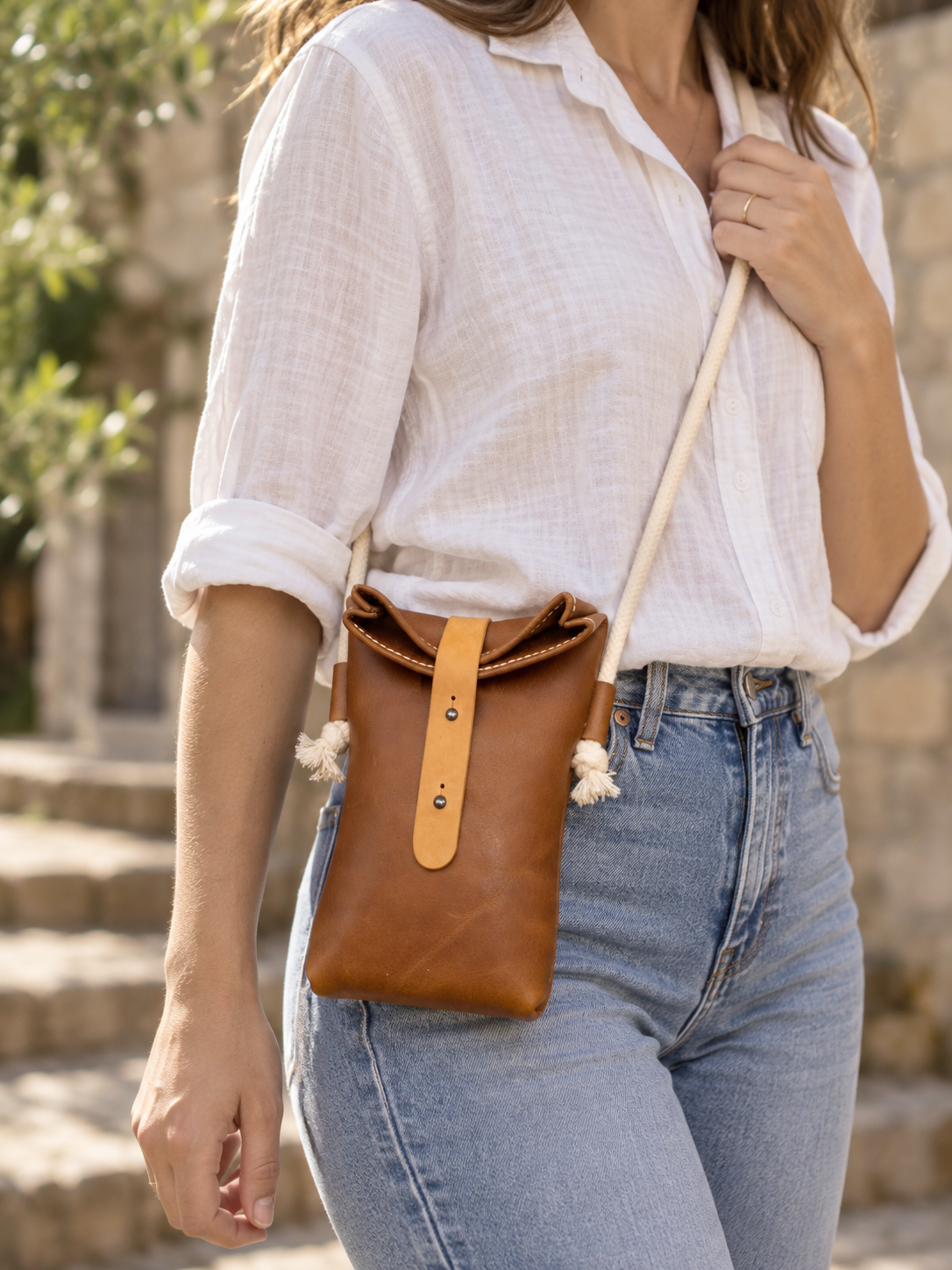 Handgefertigte Leder-Rolltop-Tasche „Mara“ mit Kordelriemen. Getragen braun